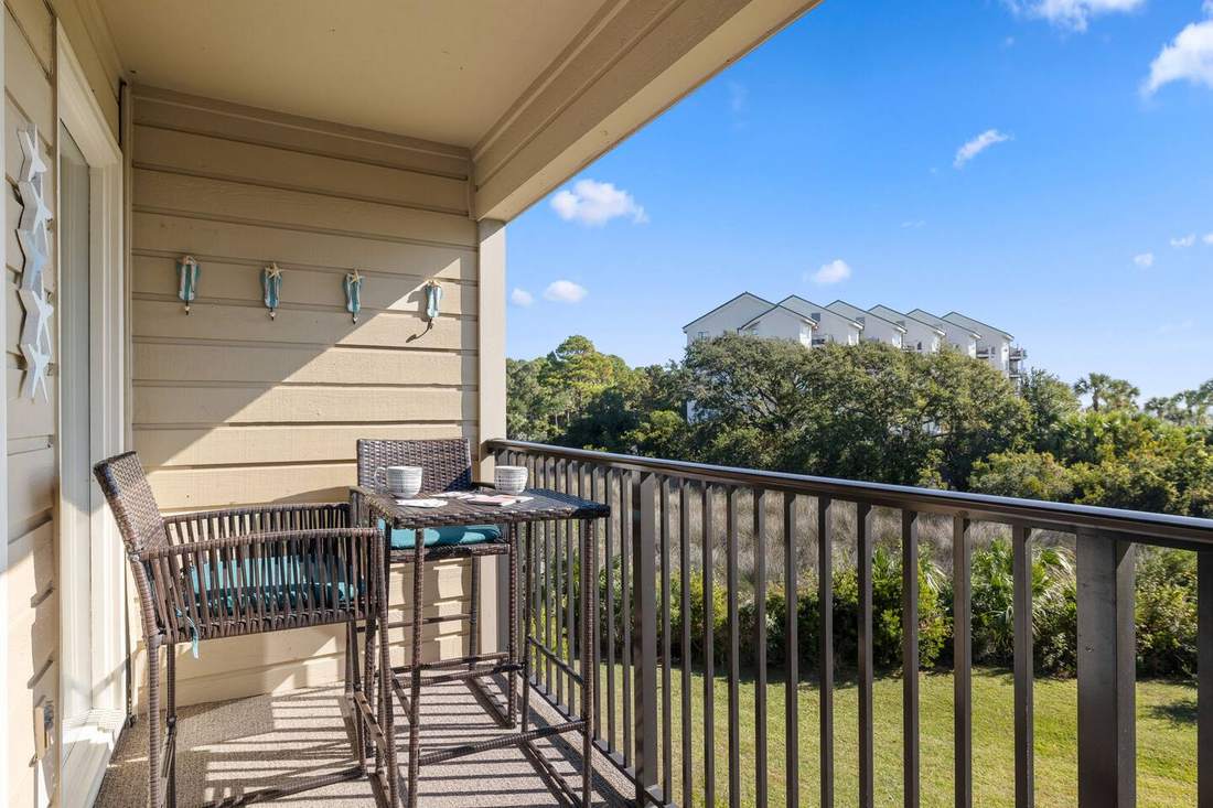 Private balcony overlooking palms, lawn and the ocean