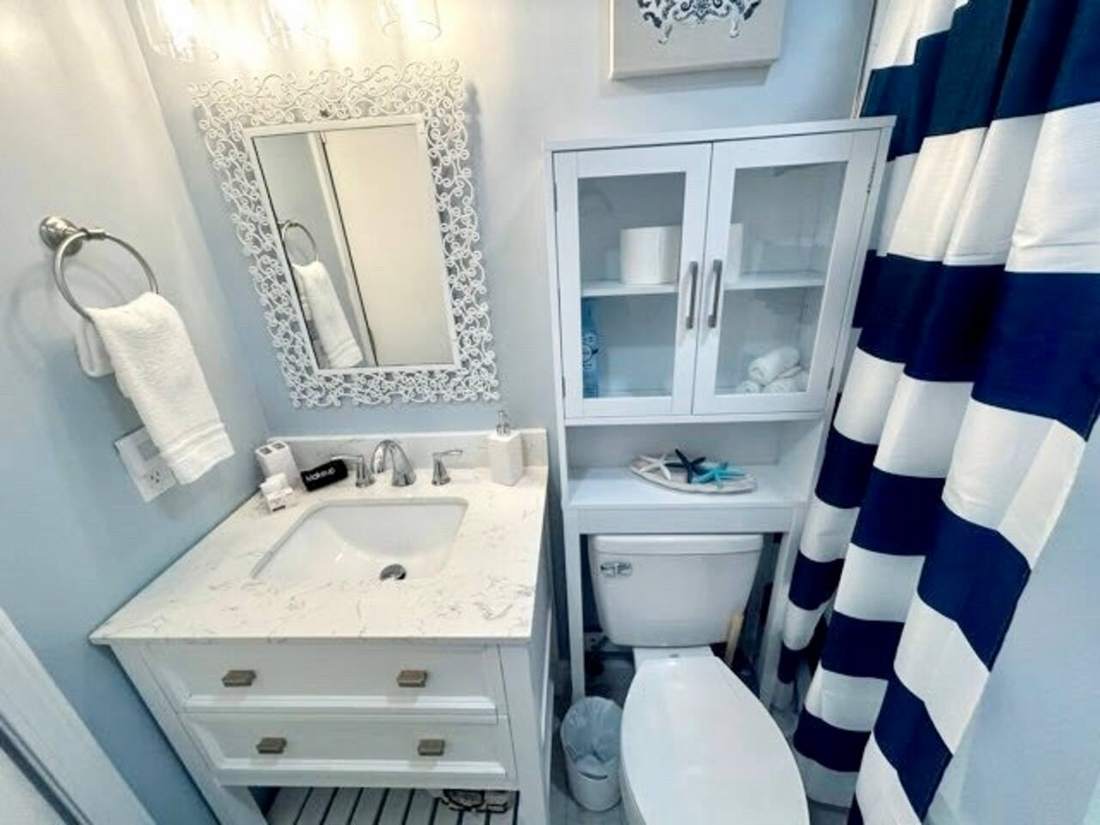 Bathroom with white vanity and striped shower curtain