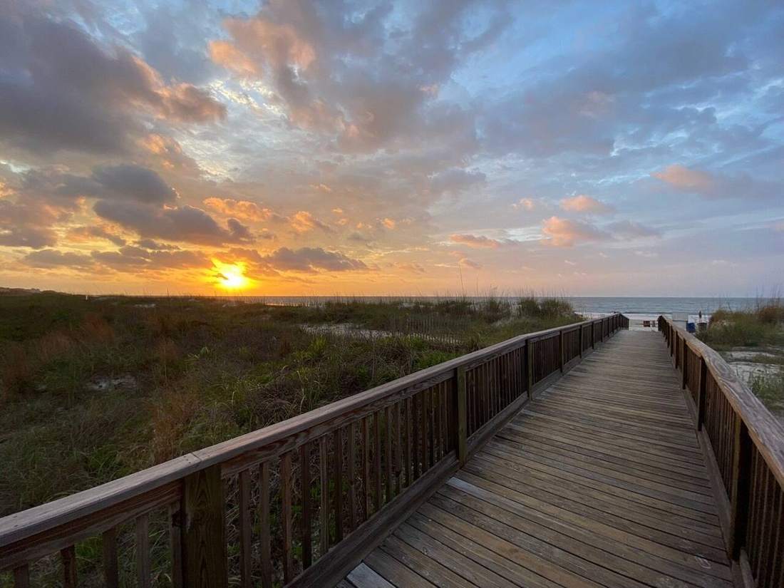 Sunrise over the boardwalk to Folly Field beach