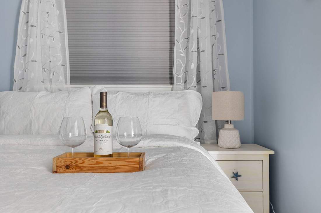 Fresh white bedding in the light blue queen bedroom